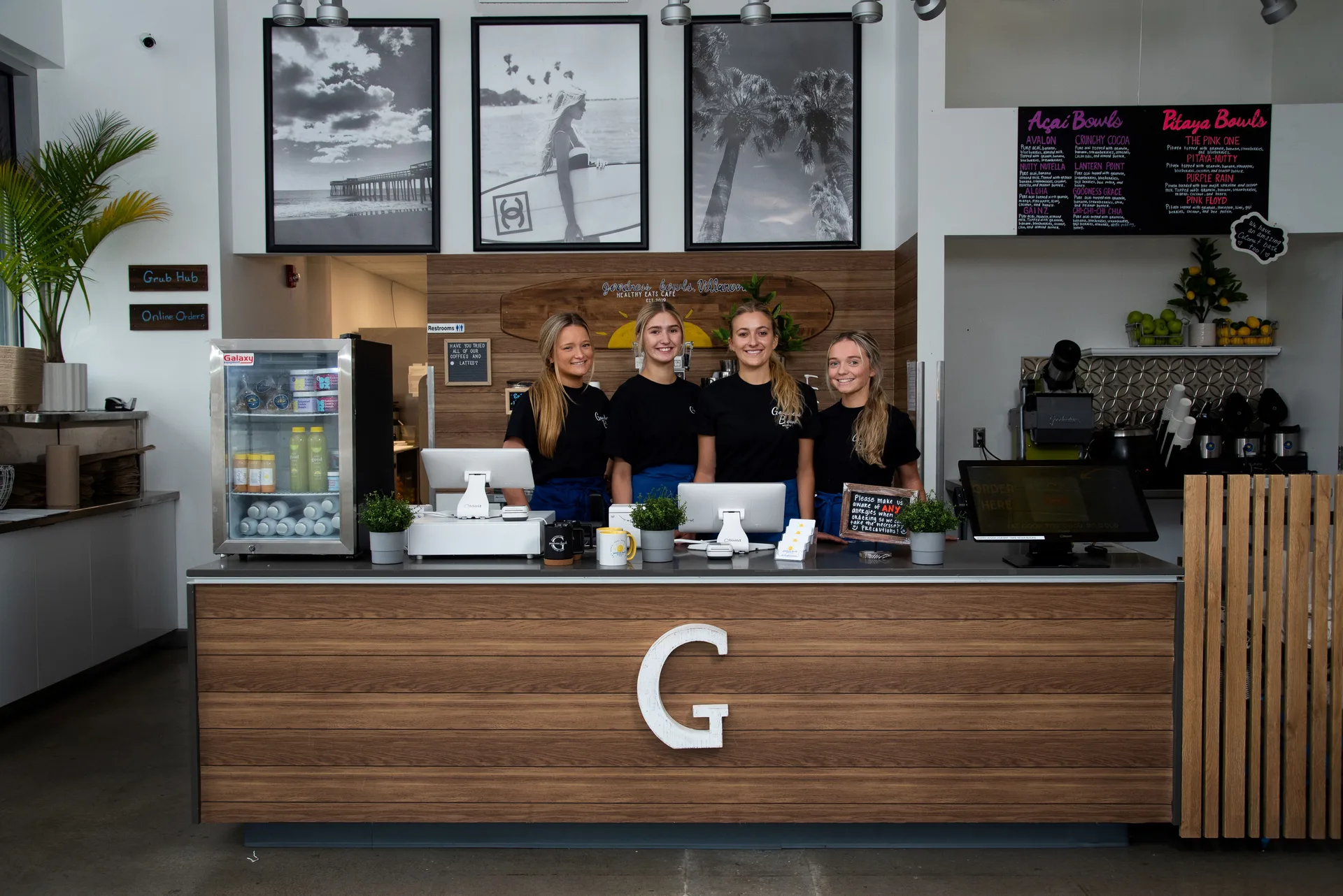 Staff members at Goodness Bowls standing behind a counter.