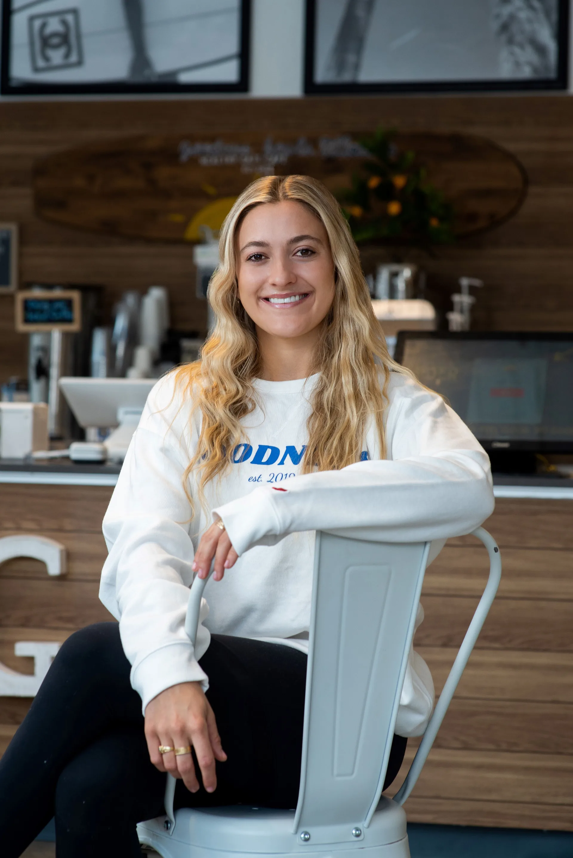 Goodness Bowls owner Corinne Persichetti sitting on a chair in the restaurant.