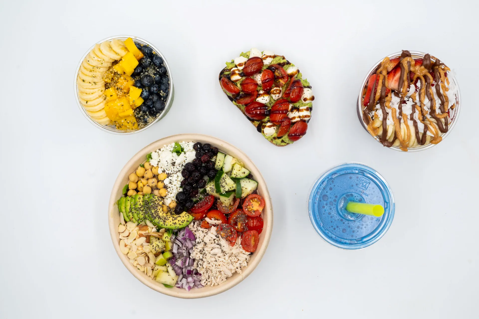 An image of a variety of food options including acai bowls, avocado toast, a salad, and a blue smoothie.