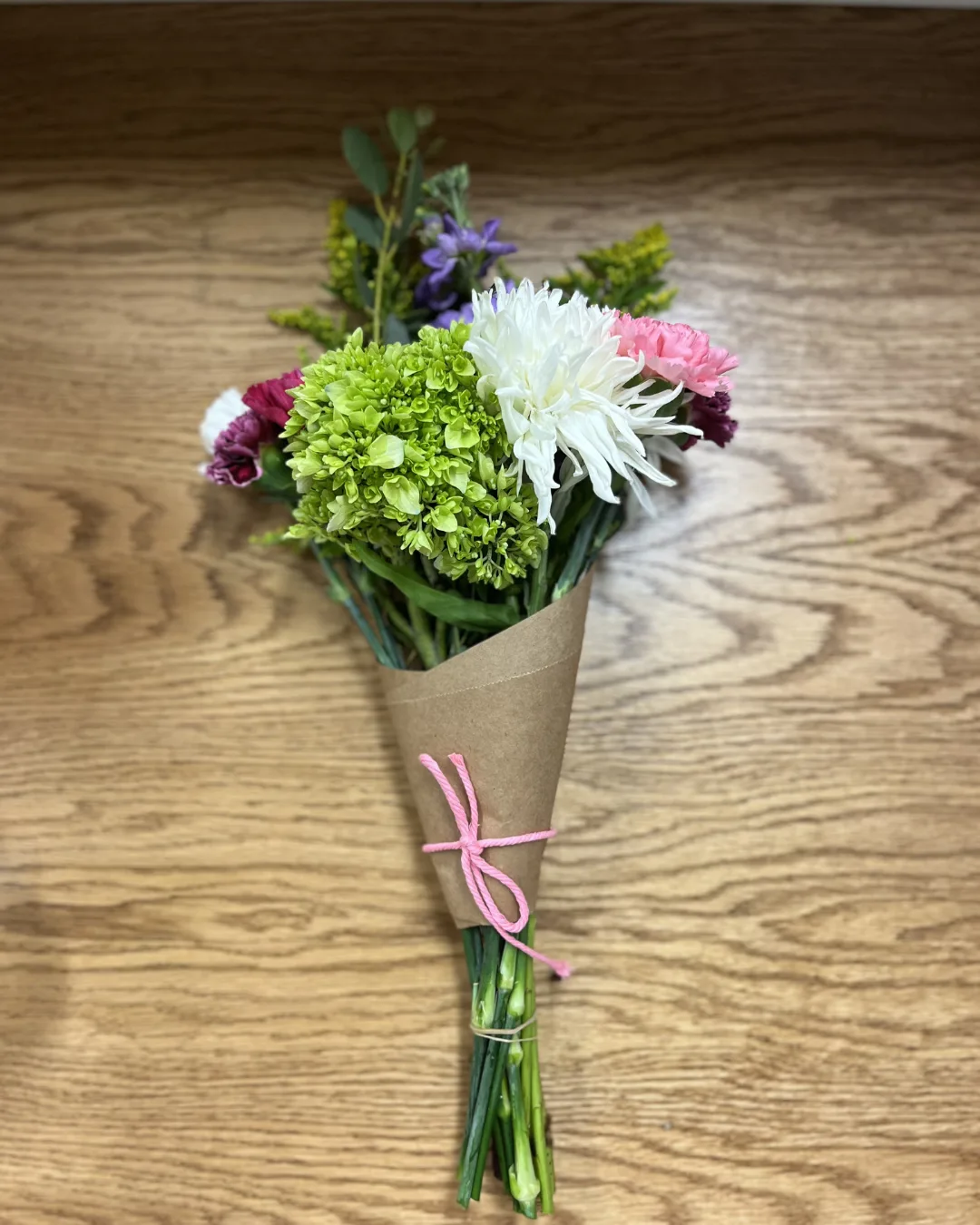 A bouquet of flowers on a wood table.