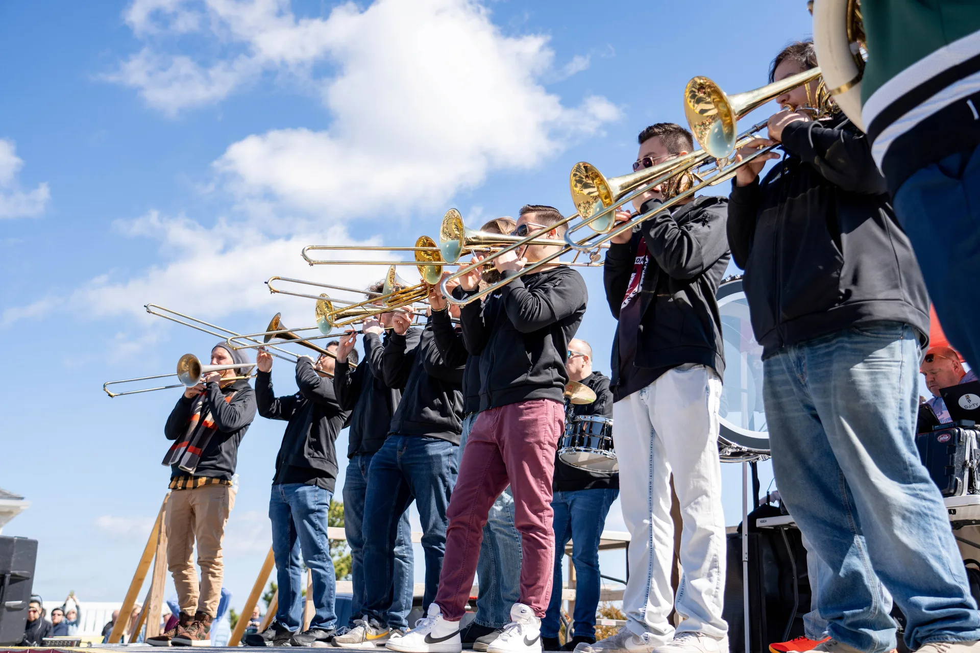 A group of men in a line playing brass instruments.
