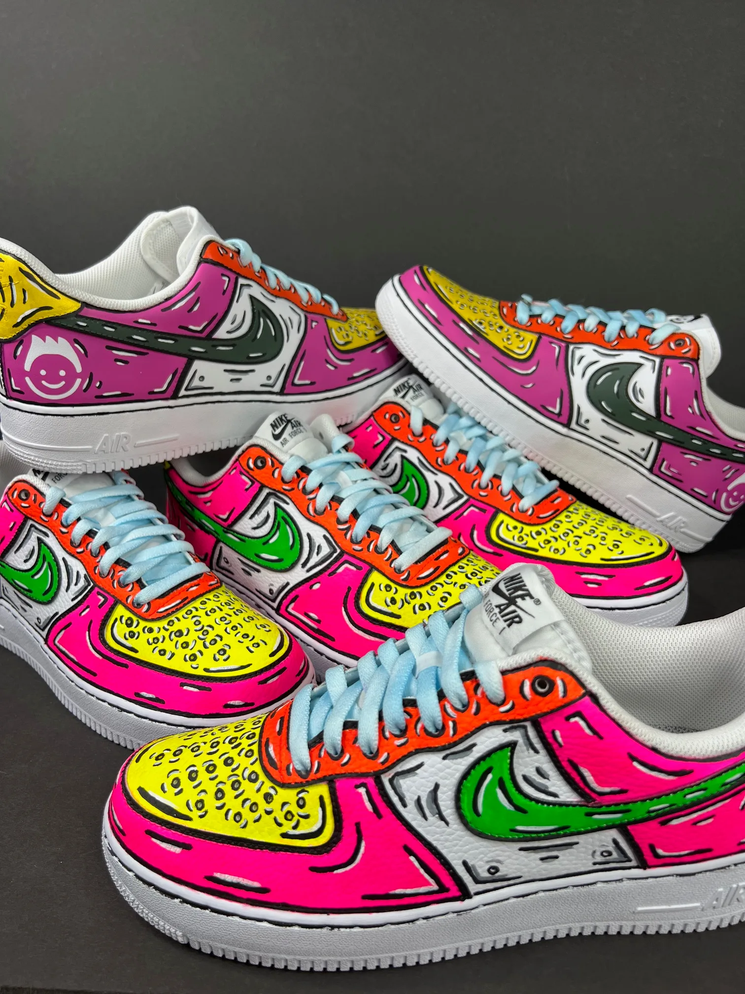A pile of sneakers decorated in multiple colors on a black background.
